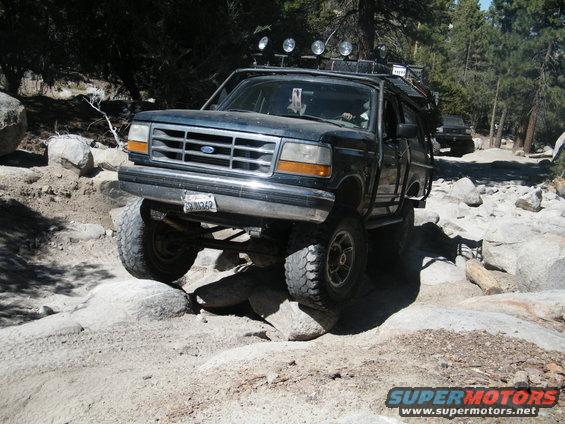 Ford Bronco navigating a rocky trail with another vehicle behind it