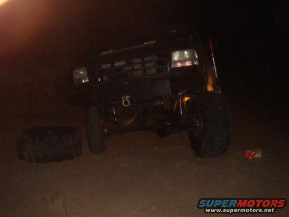 Black 1992 Ford Bronco with a flat tire and a spare tire on the ground