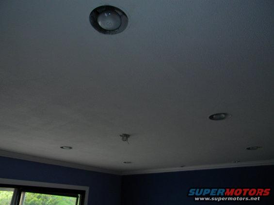 Recessed ceiling lights in a room with blue walls and a window