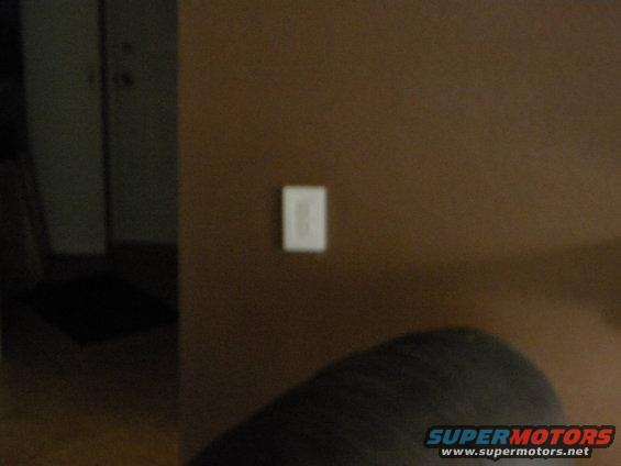 Interior wall with light switch and Supermotors.net watermark