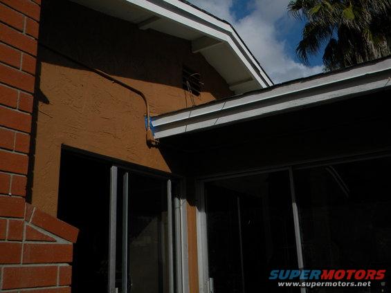 House exterior with stucco walls, brick chimney, and sliding glass doors