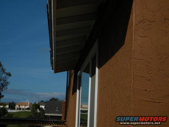 View of houses and blue sky from under a house overhang