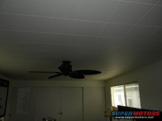 Ceiling fan mounted on a textured ceiling, with sliding doors and a window visible below