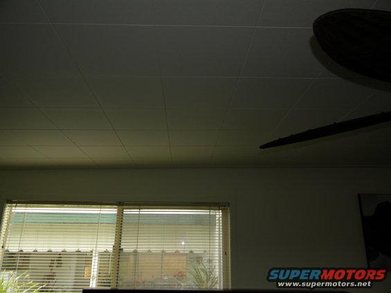 Interior scene with blinds on windows, a ceiling fan, and a "SUPERMOTORS" logo