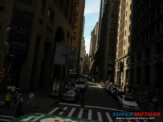 Street view of tall buildings and parked cars on a sunny day
