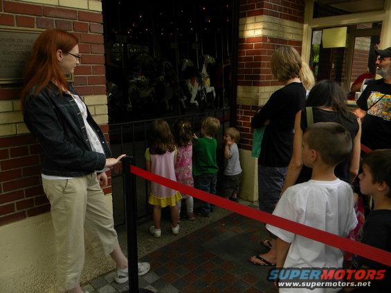Children and adults watch carousel horses
