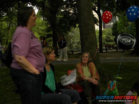 People gathered in a park with balloons and a football-themed decoration
