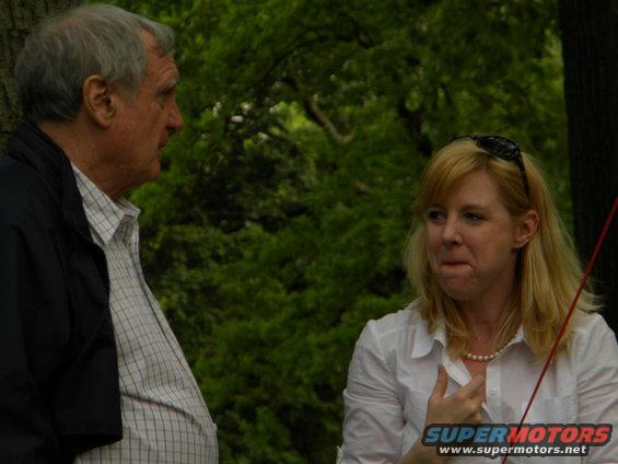 Two people talking outdoors with a watermark