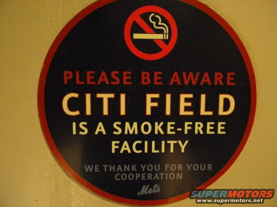 Circular sign with red border, dark blue background, and white text stating 'CITI FIELD IS A SMOKE-FREE FACILITY'