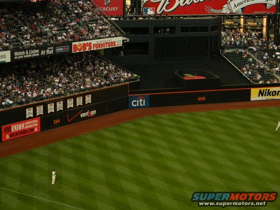 Baseball stadium with green field and stands full of spectators