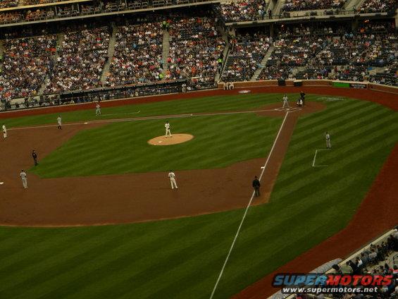 Baseball stadium with players on field and spectators in stands
