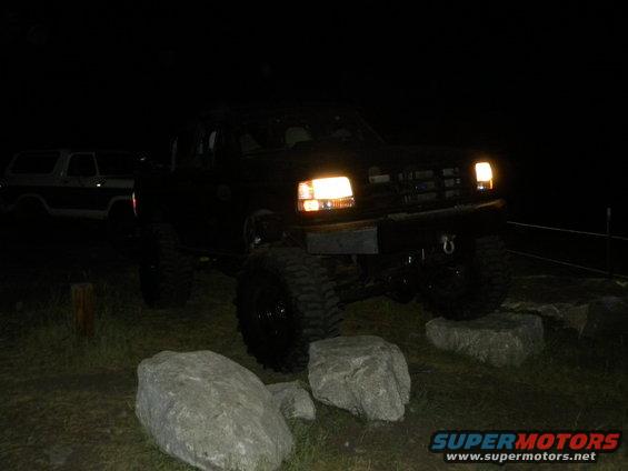 1992 Ford Bronco parked at night with headlights on, another Bronco visible in background