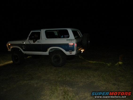 White and blue Ford Bronco with spare tire on back, lifted suspension