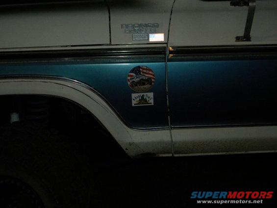 1992 Ford Bronco side view, blue and white two-tone paint, with 'Bronco' badge and stickers