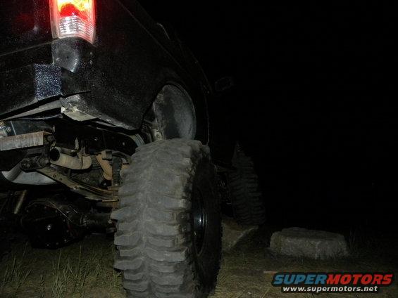 Off-road vehicle's large tire and rear axle assembly at night