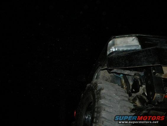 Black 1992 Ford Bronco front tire and fender, low angle view