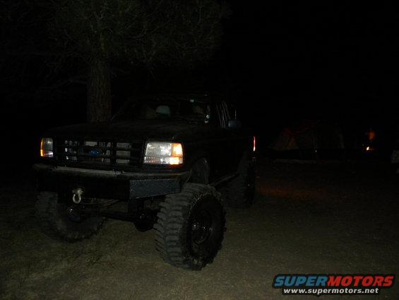 1992 Ford Bronco front grille and large tires at night