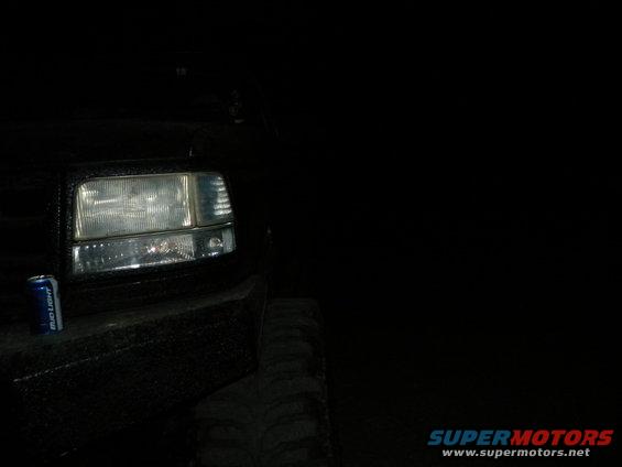 1992 Ford Bronco headlight and tire with a can of Bud Light on the bumper