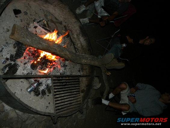 Fire burning in darkness, with debris and glowing embers visible