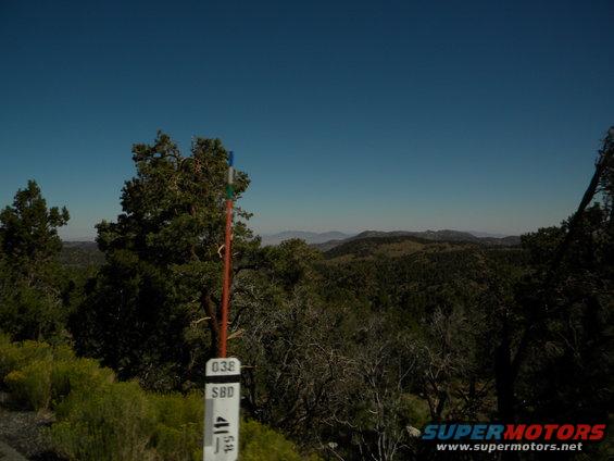 Mountain landscape with a marker post showing numbers 038 and SBD