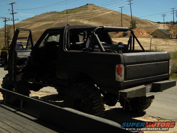 Black 1992 Ford Bronco with roll cage and lifted suspension, rear 3/4 view