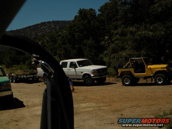 1992 Ford F-Series truck parked next to a yellow Jeep; trailer visible behind truck