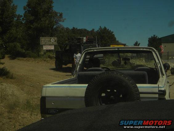 White SUV with spare tire, blue stripe, and Ford badge visible