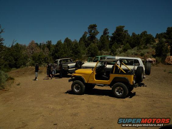 Yellow Jeep Wrangler parked with Ford Bronco and pickup truck