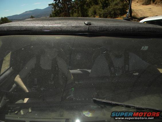 Interior view through dusty windshield of an SUV, showing dashboard and seats