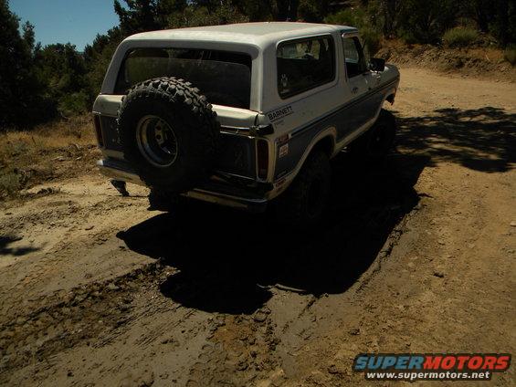 Ford Bronco on a dirt road, spare tire mounted on the back
