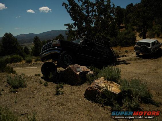 1992 Ford Bronco on a dirt road with another SUV in the background