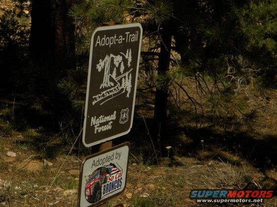 Adopt-a-Trail sign with National Forest logo and a smaller sign saying 'Adopted by So Cal BRONCOS' with a picture of a red Bronco
