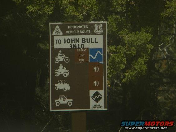 Sign for designated vehicle route to John Bull, showing icons for motorcycle, ATV, and two types of trucks