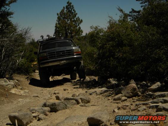 Ford F-Series truck driving on a rocky trail