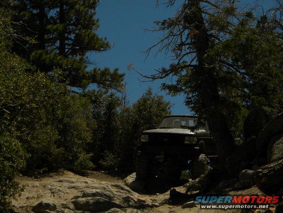 1992 Ford Bronco on a rocky, wooded trail