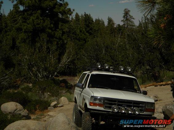White 1992 Ford Bronco with roof and bumper lights on rocky terrain