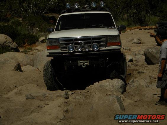 White 1992 Ford Bronco with off-road lights navigating a rocky path