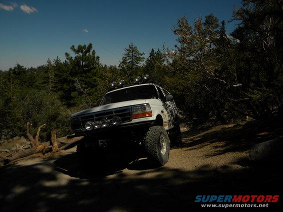 White 1992 Ford Bronco with off-road lights on a dirt trail