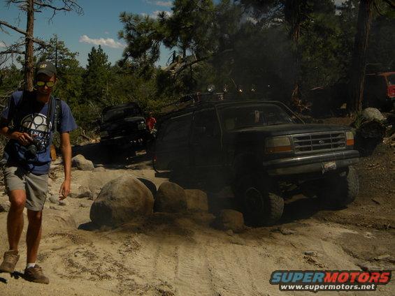 Dark 1992 Ford Bronco off-roading on rocky terrain