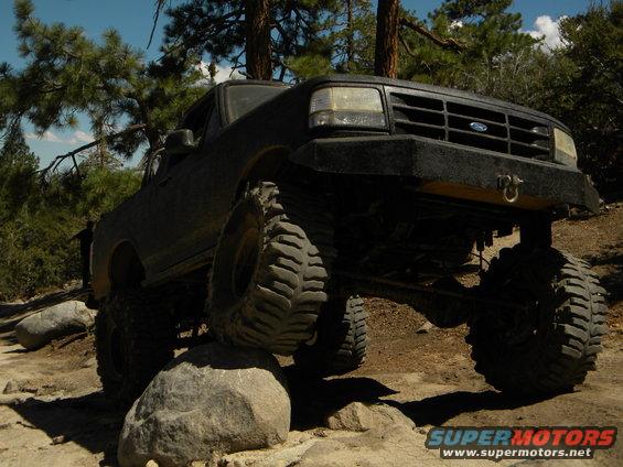 Black Ford Bronco on rocks, front end lifted