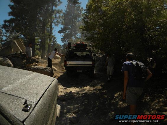 Black 1992 Ford Bronco on a rocky trail with people around