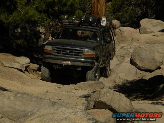 1992 Ford Bronco on rocky trail, front 3/4 view, black