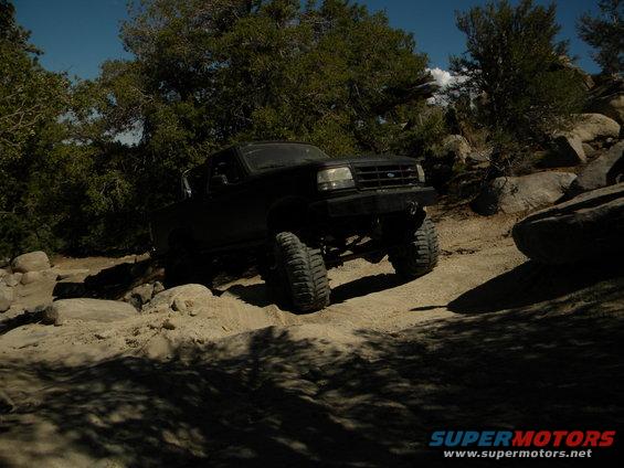 Black 1992 Ford Bronco off-roading on rocky terrain