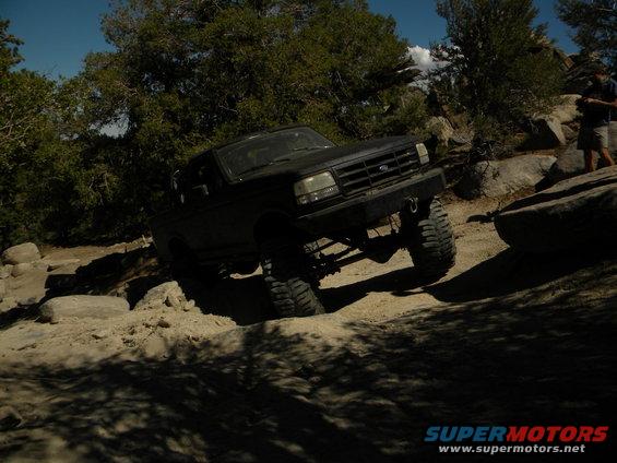 Black 1992 Ford Bronco climbing rocks on a dirt trail