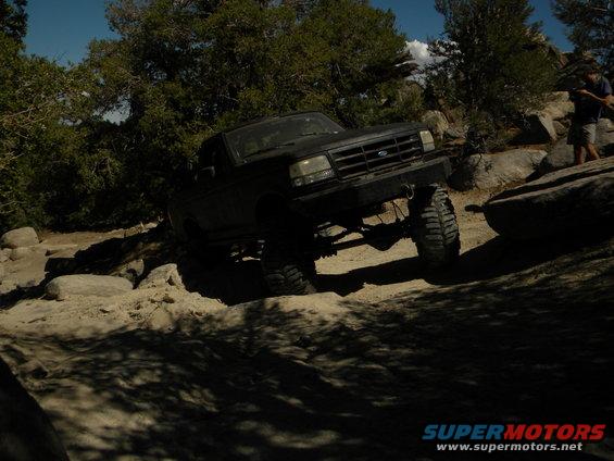 Black Ford F-Series truck off-roading over rocks