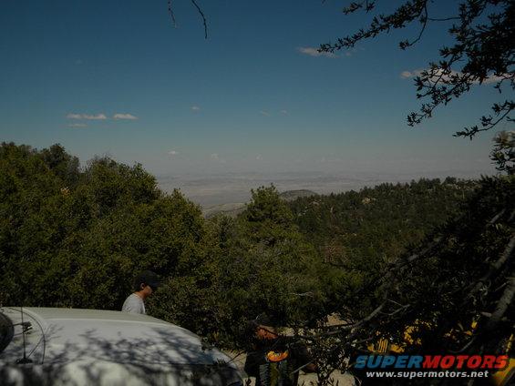 White SUV parked on a dirt road with a person standing next to it