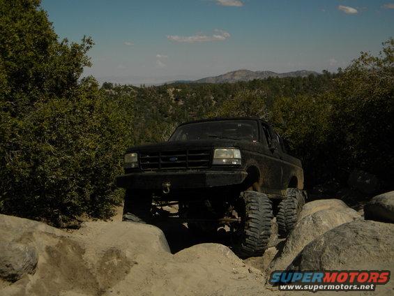 1992 Ford Bronco navigating a rocky trail with large tires