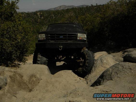 Black SUV with large tires navigating rocky terrain