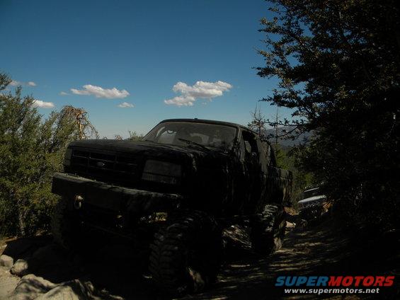 Black 1992 Ford Bronco on a rocky, wooded trail, front-left view