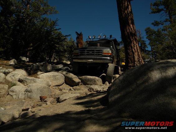 Black 1992 Ford Bronco navigating a rocky trail, front view